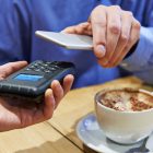 Irish Shoppers Flocking To Paying By Contactless And Mobile Man Using Contactless Payment App On Mobile Phone In Cafe