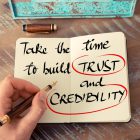 Adding Some Trust Signals to our web and Social Presence Retro effect and toned image of a woman hand writing a note with a fountain pen on a notebook. Handwritten text Take The Time To Build Trust and Credibility as business concept image
