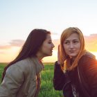 Tá Gach Seachtain ina Seachtain na Gaeilge ar an Idirlíon! people communication and friendship concept- Two girl friends whispering secrets