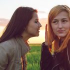 Tá Gach Seachtain ina Seachtain na Gaeilge ar an Idirlíon! people communication and friendship concept- Two girl friends whispering secrets