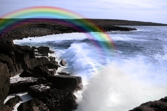 cliffs and coastline of the burren in county clare ireland with waves crashing on the rocks causing rainbow