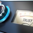 Maintaining Trust, Respecting Privacy and Due Process Hand turning a knob up to the maximum Concept image for illustration of trust in business.