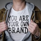 Build Your Personal Brand Man showing You Are Your Own Brand tittle on t-shirt. Personal branding concept.