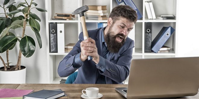 Man attacking computer with hammer